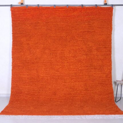 Authentic handmade Moroccan orange Beni Ourain rug crafted with 100% natural wool by Berber artisans, featuring vibrant rustic orange color and traditional geometric Berber tribal patterns, perfect for living rooms and cozy interiors.