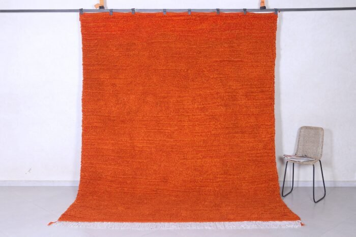 Authentic handmade Moroccan orange Beni Ourain rug crafted with 100% natural wool by Berber artisans, featuring vibrant rustic orange color and traditional geometric Berber tribal patterns, perfect for living rooms and cozy interiors.