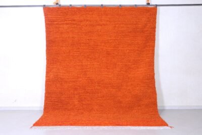 Right side view of a vibrant orange Moroccan wool rug, hand-knotted with traditional Berber Beni Ourain tribal designs, showcasing soft natural lamb’s wool texture and warm rustic hues.