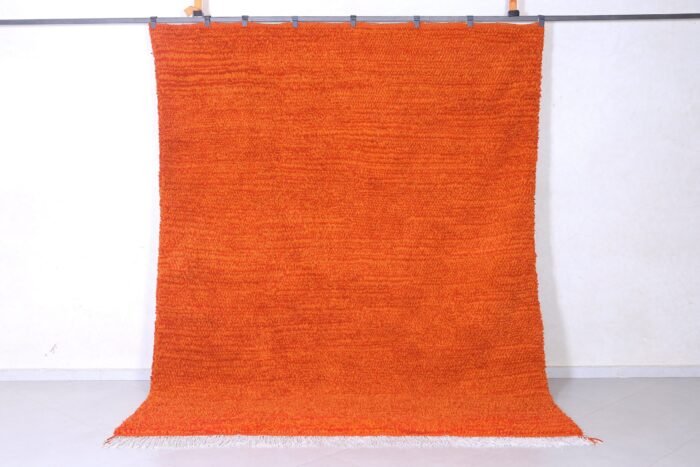 Right side view of a vibrant orange Moroccan wool rug, hand-knotted with traditional Berber Beni Ourain tribal designs, showcasing soft natural lamb’s wool texture and warm rustic hues.