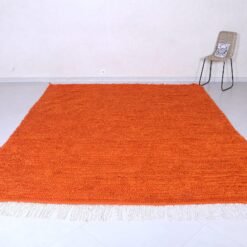 Left angle of handmade Moroccan orange rug, illustrating fine Berber craftsmanship with durable 100% natural wool, vibrant rustic orange tone, and authentic geometric tribal motifs.