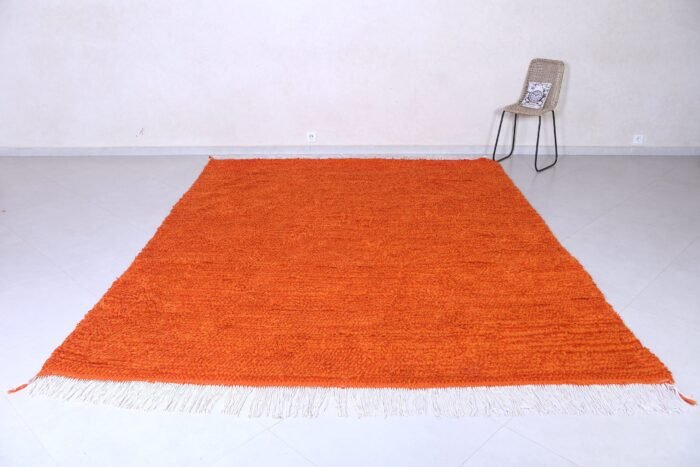 Left angle of handmade Moroccan orange rug, illustrating fine Berber craftsmanship with durable 100% natural wool, vibrant rustic orange tone, and authentic geometric tribal motifs.