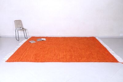 Moroccan orange Beni Ourain rug, highlighting the detailed tribal pattern and thick, soft wool fibers handwoven by skilled Moroccan artisans.