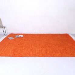Moroccan orange Beni Ourain rug, highlighting the detailed tribal pattern and thick, soft wool fibers handwoven by skilled Moroccan artisans.