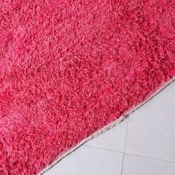 Fringe detail of Moroccan rose pink wool rug with artisanal finish.