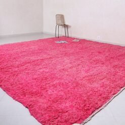 Left view of Berber handmade rose pink wool rug with solid design.
