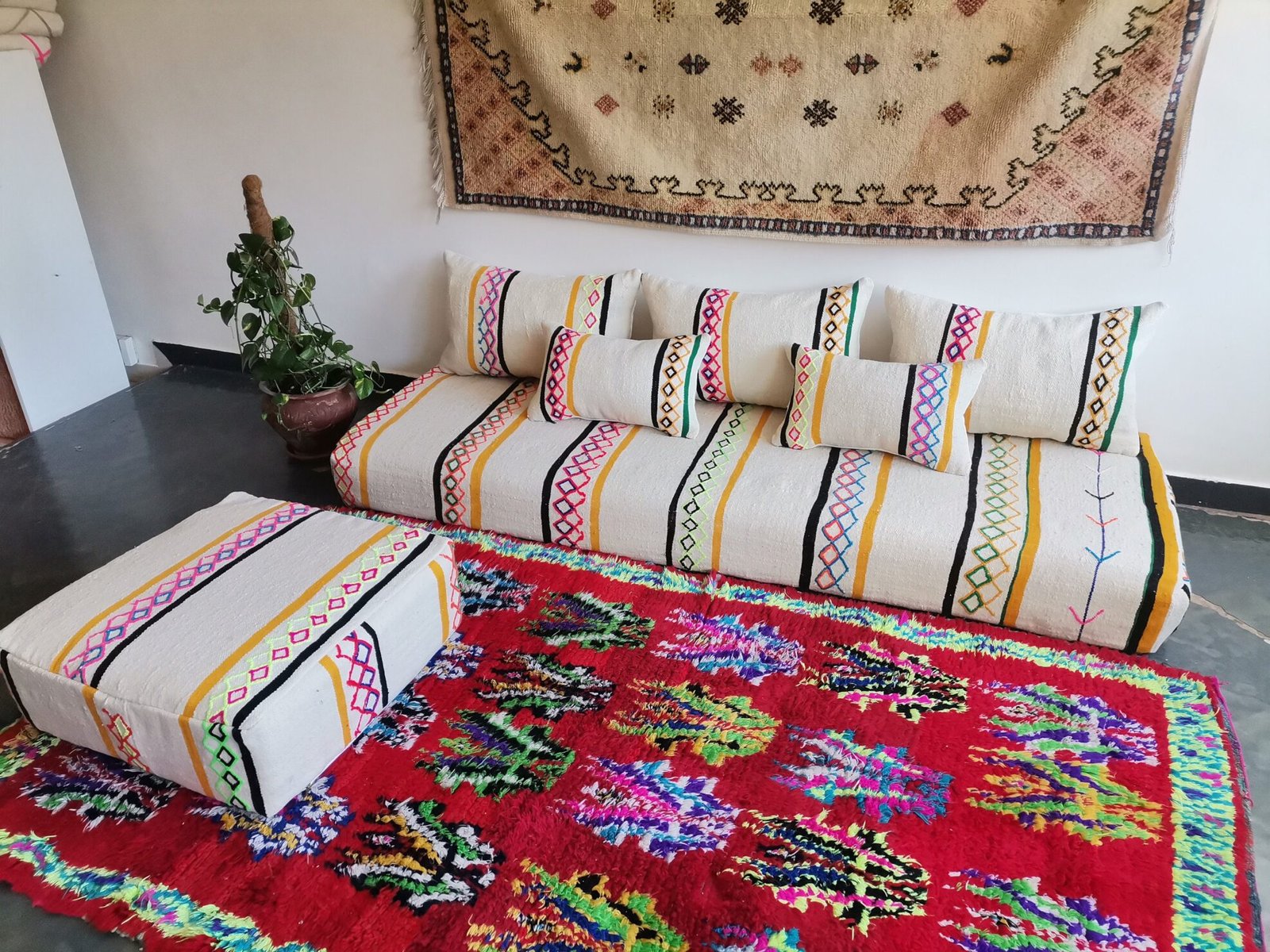 Side view of ivory base Moroccan floor cushion with bright embroidery