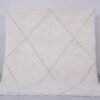 Handmade Moroccan rug with crisp white base and delicate tan trellis pattern, woven from 100% natural lamb wool by skilled Berber artisans in Morocco.