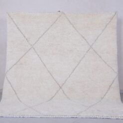 Handmade Moroccan rug with crisp white base and delicate tan trellis pattern, woven from 100% natural lamb wool by skilled Berber artisans in Morocco.
