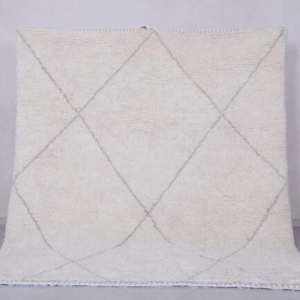 Handmade Moroccan rug with crisp white base and delicate tan trellis pattern, woven from 100% natural lamb wool by skilled Berber artisans in Morocco.
