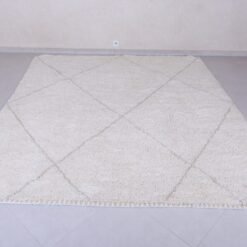 white Moroccan rug with tan trellis pattern.