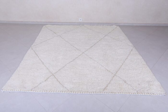 white Moroccan rug with tan trellis pattern.
