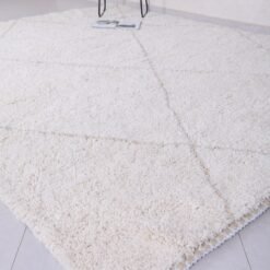 hand-knotted fringe on white and tan Moroccan rug, showcasing authentic artisan finishing techniques.