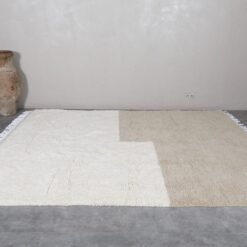 Moroccan hand-knotted Beni Ourain rug in ivory and taupe, highlighting soft wool texture and traditional Berber weaving.