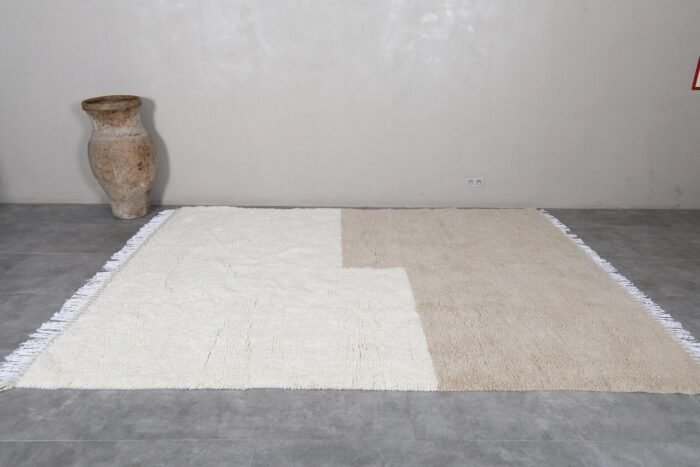 Moroccan hand-knotted Beni Ourain rug in ivory and taupe, highlighting soft wool texture and traditional Berber weaving.