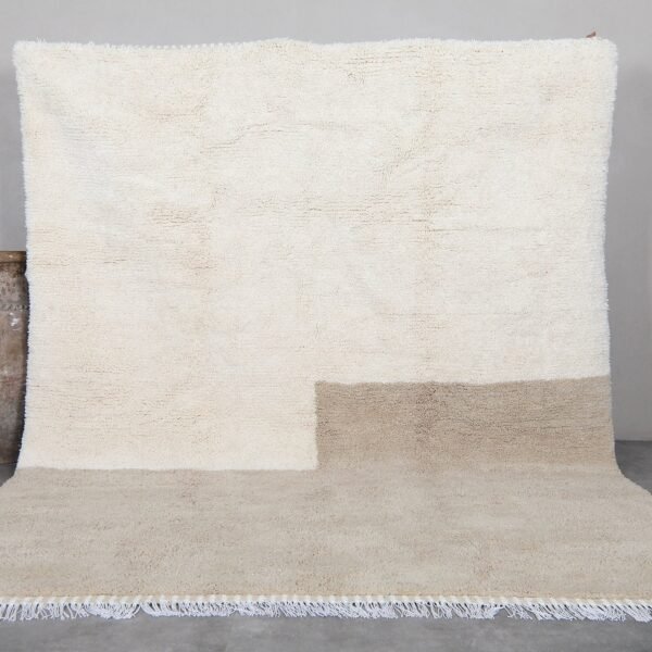 Contemporary Moroccan rug in elegant ivory and taupe tones, hand-knotted by Berber artisans using 100% natural lamb wool, perfect for modern and minimalist interiors.