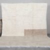 Contemporary Moroccan rug in elegant ivory and taupe tones, hand-knotted by Berber artisans using 100% natural lamb wool, perfect for modern and minimalist interiors.