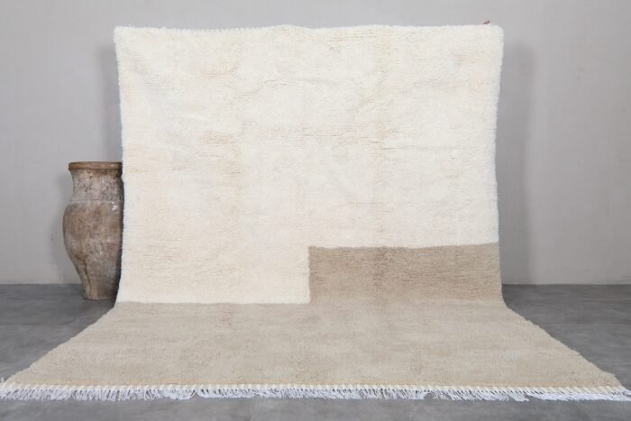 Contemporary Moroccan rug in elegant ivory and taupe tones, hand-knotted by Berber artisans using 100% natural lamb wool, perfect for modern and minimalist interiors.