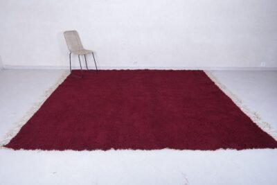 handmade Moroccan burgundy rug with thick wool pile, highlighting the luxurious texture, minimalist elegance, and cultural authenticity of Beni Ourain weaving.