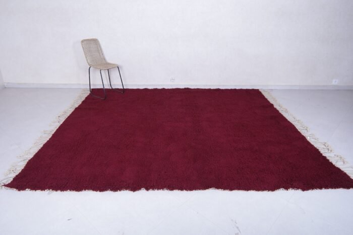 handmade Moroccan burgundy rug with thick wool pile, highlighting the luxurious texture, minimalist elegance, and cultural authenticity of Beni Ourain weaving.