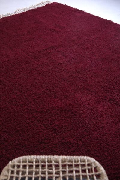 Moroccan burgundy wool rug, featuring artisan knotting and traditional fringes—crafted in the Atlas Mountains with care and authentic Berber tradition.