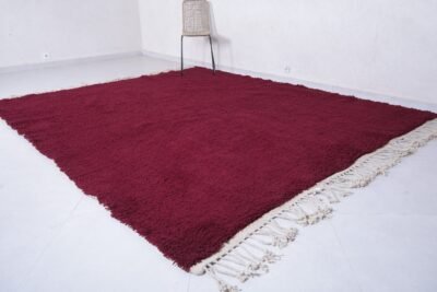 solid burgundy Moroccan rug, hand-knotted by skilled Berber women using natural wool—an elegant floor piece for contemporary or rustic interiors.