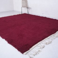 solid burgundy Moroccan rug, hand-knotted by skilled Berber women using natural wool—an elegant floor piece for contemporary or rustic interiors.