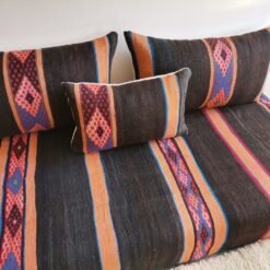Side view of black and orange Moroccan floor cushion with visible embroidered stripe