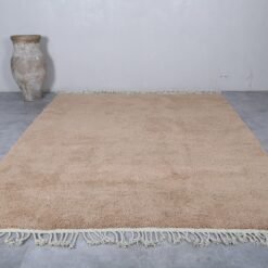 wool texture and natural fibers of a sand brown Moroccan Beni Ourain rug, with visible hand-knotting details and warm neutral tone.