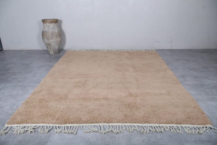 wool texture and natural fibers of a sand brown Moroccan Beni Ourain rug, with visible hand-knotting details and warm neutral tone.