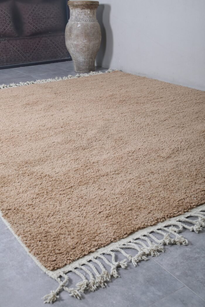 handmade Moroccan rug in sand brown, with clean edges and optional fringe. A perfect solid rug for serene and earthy home design.