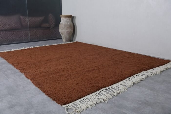 fringe on handmade Moroccan dark brown wool rug, showing artisanal finishing.