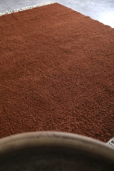 Moroccan dark brown Beni Ourain rug highlighting dense wool fibers.
