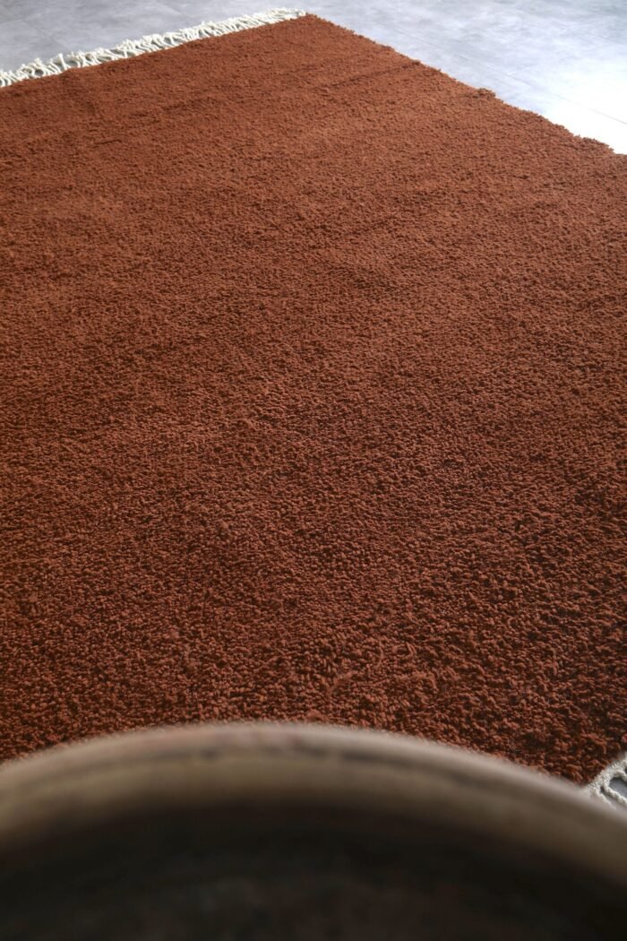 Moroccan dark brown Beni Ourain rug highlighting dense wool fibers.