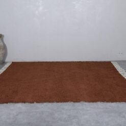 handcrafted Moroccan dark brown wool rug with tribal Berber patterns.