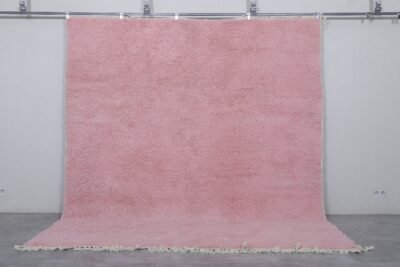 Moroccan millennial pink wool rug, highlighting its hand-knotted texture, soft pastel tone, and thick, plush wool surface made by Berber artisans in Morocco.