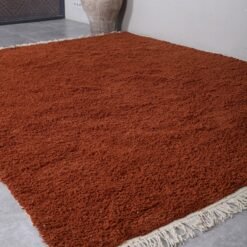 handmade Moroccan wool rug in warm terracotta color, featuring soft natural fibers and authentic Berber weaving from the Atlas Mountains
