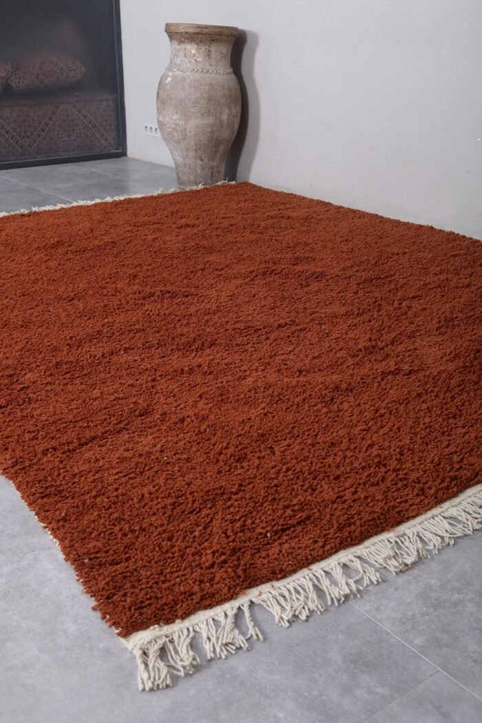 handmade Moroccan wool rug in warm terracotta color, featuring soft natural fibers and authentic Berber weaving from the Atlas Mountains
