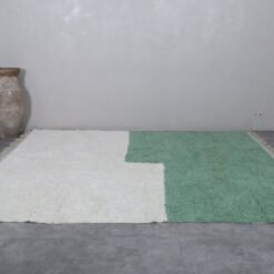Moroccan Beni Ourain rug in ivory and green, highlighting its natural wool fibers and elegant tribal pattern.