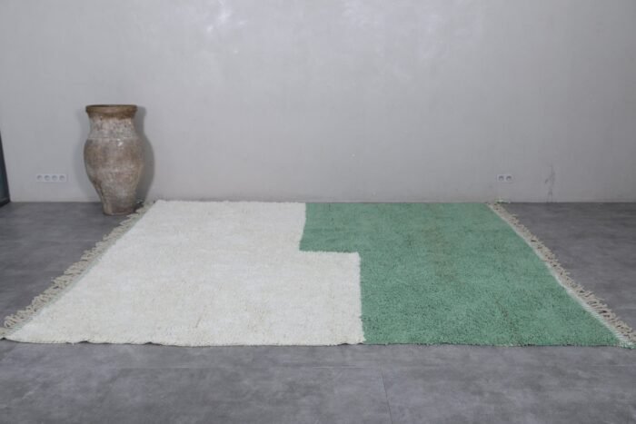 Moroccan Beni Ourain rug in ivory and green, highlighting its natural wool fibers and elegant tribal pattern.
