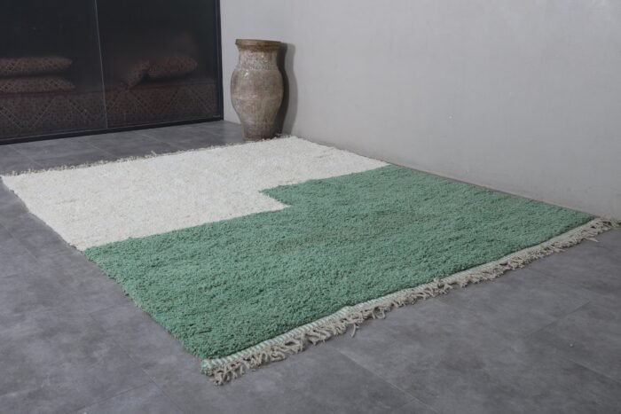 ivory Moroccan wool rug with fresh green detailing, showcasing its thick, soft texture and hand-knotted craftsmanship.