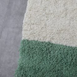 Macro zoom showing soft lamb wool texture in the ivory and green handmade Moroccan rug, ideal for natural decor themes.