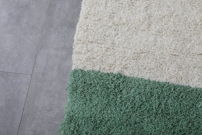 Macro zoom showing soft lamb wool texture in the ivory and green handmade Moroccan rug, ideal for natural decor themes.