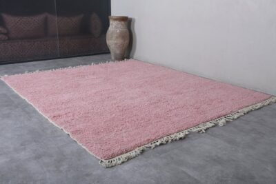 Moroccan millennial pink area rug showing the clean, solid-colored surface, perfect symmetry, and detailed fringe on both sides, handcrafted in Morocco.
