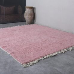 Moroccan millennial pink area rug showing the clean, solid-colored surface, perfect symmetry, and detailed fringe on both sides, handcrafted in Morocco.