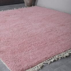 millennial pink Moroccan rug's soft wool fibers, rich handmade details, and subtle texture, woven with care by Berber women in the Atlas Mountains.