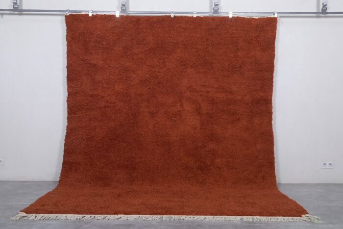 Handmade Moroccan warm terracotta wool rug in solid color, crafted by Berber artisans using 100% natural lamb wool, perfect for boho, rustic, and modern interiors with a cozy, earthy aesthetic.