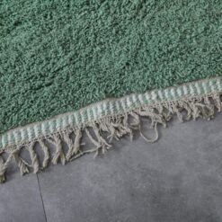 fringe and weave on ivory and green Moroccan wool rug, reflecting traditional Berber finishing techniques and authentic artisan work.