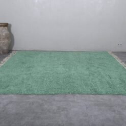 Moroccan Berber rug, displaying its solid color, symmetrical shape, and authentic fringe edges. A perfect handmade centerpiece for peaceful, bright home decor.