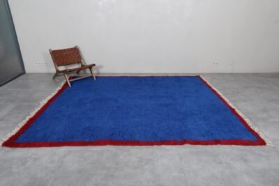Moroccan Blue Beni Ourain rug illustrating its authentic Berber design and vibrant blue coloration. Hand-knotted with natural sheep wool by Moroccan women artisans, this perspective highlights the rug’s thickness, texture, and cultural significance, making it a perfect centerpiece for large rooms or statement décor.
